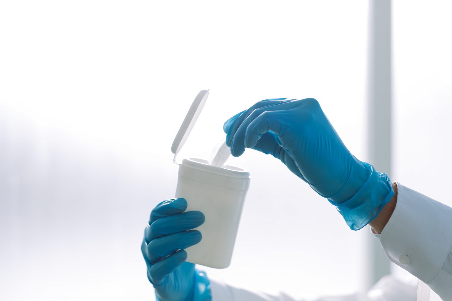 image of a doctor taking a wet wipe out of a container